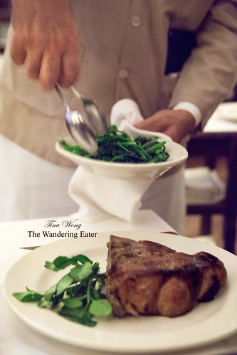 Grilled double-cut veal chop and our waiter serving our broccoli rabe