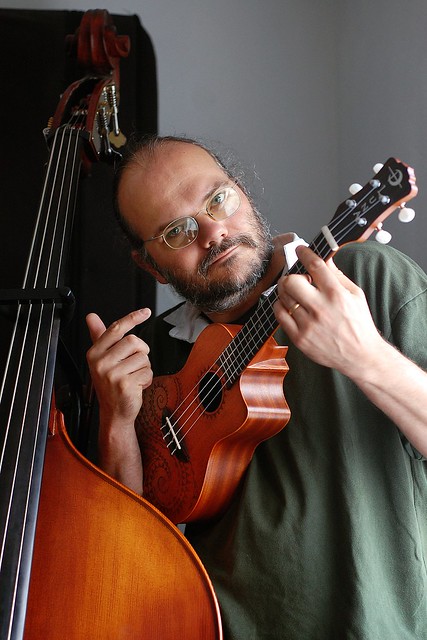 Wulf holding a small ukulele, standing next to his double bass