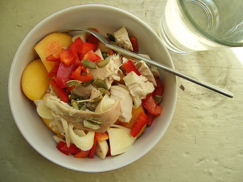 chicken, hearts of palm, red pepper, and pepita salad on sliced peaches