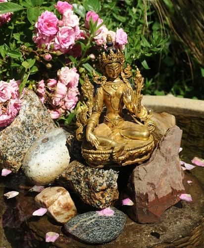 Small gold statue of Lady Tara, enlighted female, holding a flower among roses, Our Lady Rocks, water fountain, A Garden for the Buddha, Tibetan Buddhist, Seattle, Washington, USA by Wonderlane