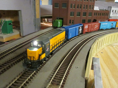 An H.O Scale Chicago & NorthWestern Railroad freight train rounding the curve in an industrial district. by Eddie from Chicago
