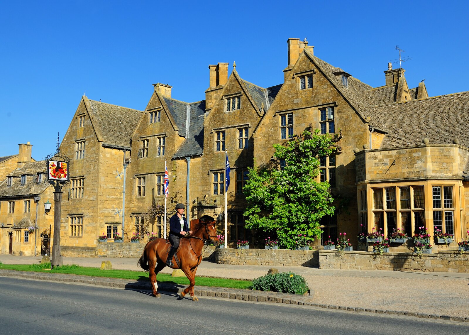 A rider passes in front of the Lygon Arms hotel in Broadway. Credit Saffron Blaze