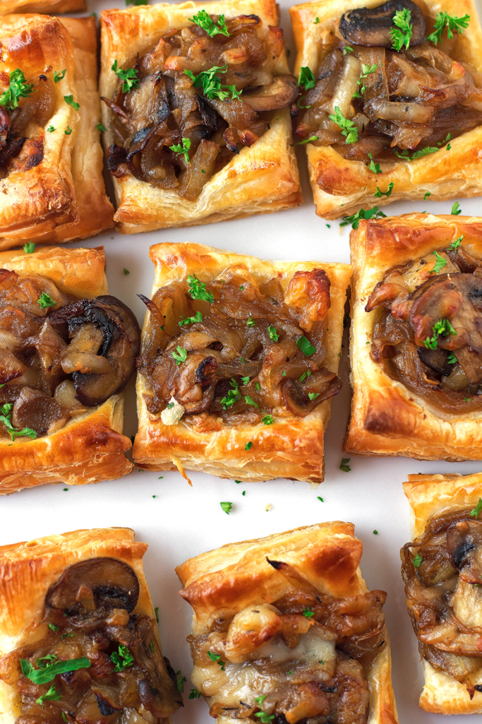 puff pastry topped with caramelized onions and parsley on dish