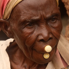 burkina faso - old lobi woman with two plugs in sansana village