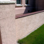 Block wall with brick cap and stucco.