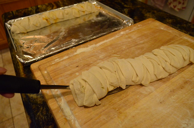 A large spatula lifting the assembled calzone off the cutting board.