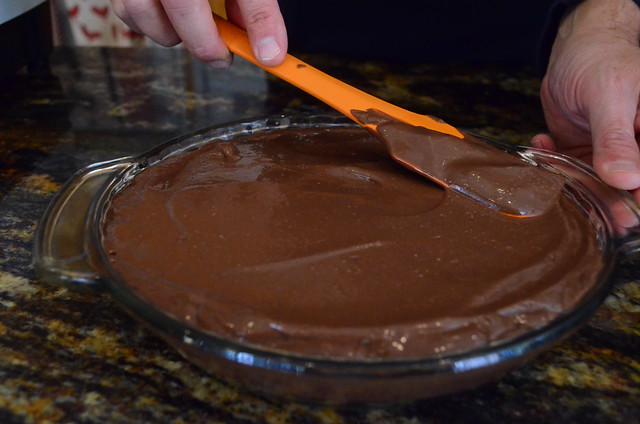 The blended pudding being smoothed out on top of the cooled brownie crust.