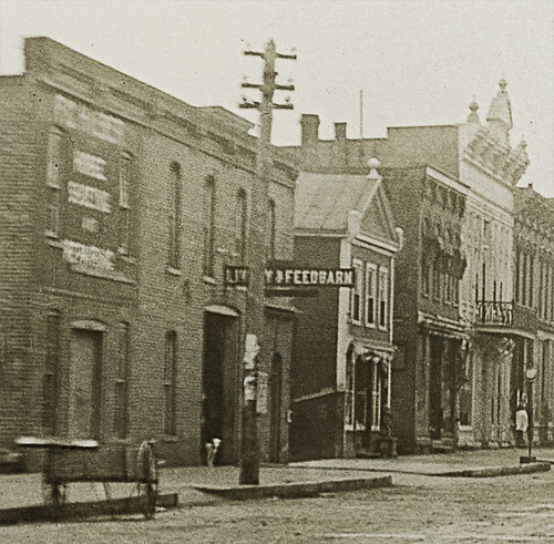 horses people usa signs man men history sepia fence buildings walking advertising hardware workmen churches indiana streetscene transportation porch shops pedestrians hotels storefronts grocery firestation ligonier banks livery noblecounty realphoto hoosierrecollections