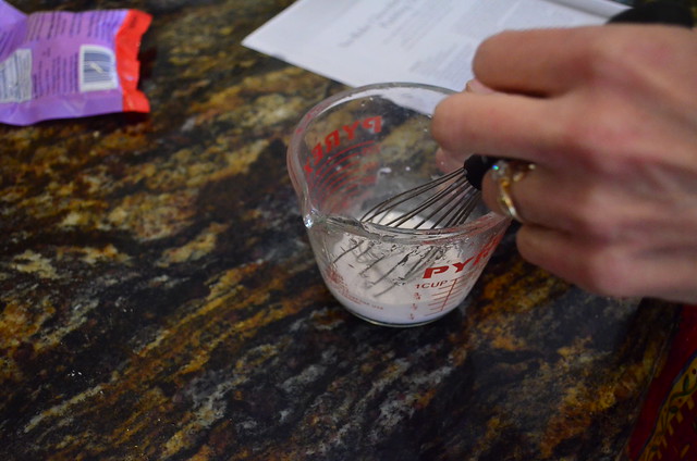 Kuzu root starch being mixed with water in a small measuring cup.