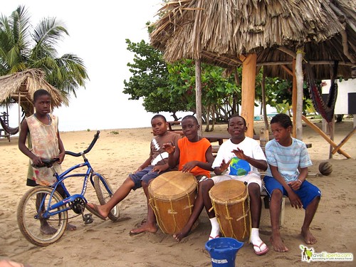 boys playing drums in a beach of hopkins village in belize