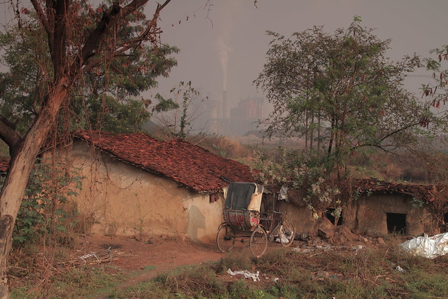 village in Chhattisgarh with a smokestack in the background