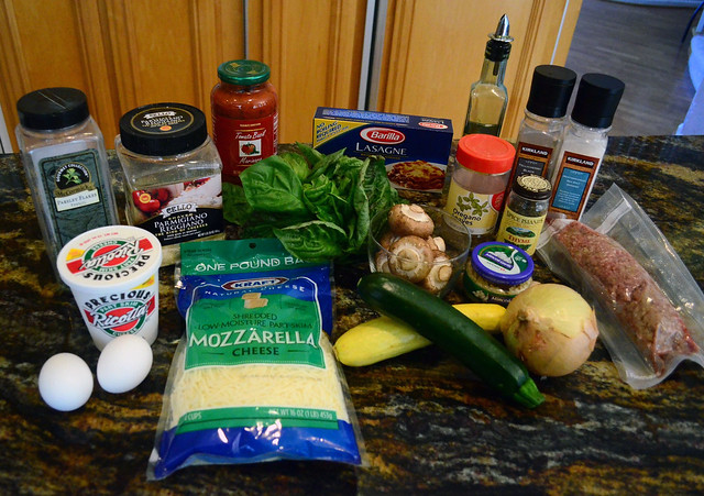 All the required ingredients to make the lasagna arranged on a counter top.
