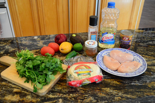 All the required ingredients for chicken tacos with mango avocado salsa arranged on a counter top.