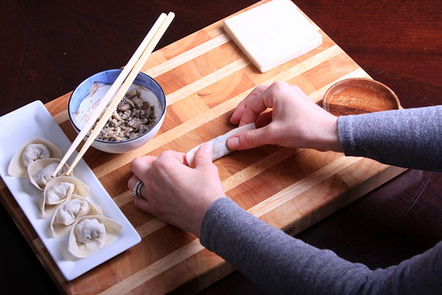 Step Six: Now fold the wonton over again, by lifting up the side that is closest to you and folding it away from you. Don't take your pinched fingers off the sides.