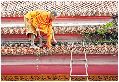 Monk cleaning temple roof at Wat Bang Riang