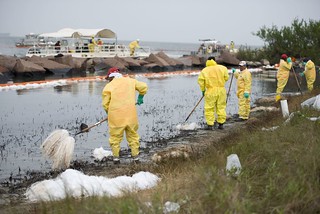 Responders work to clean the remaining oil — with pompoms, rakes and power washers — from some of the worst hit parts of Galveston Island on the northeast end near Boddecker Rd. April 3, 2014. Southeast winds pushed oil onto the shorelines facing the Houston Ship Channel as the tides carried oil out into the gulf after a nearly 168,000 gallon spill near Texas City March 22. U.S. Coast Guard photo by Petty Officer 1st Class Andrew Kendrick.