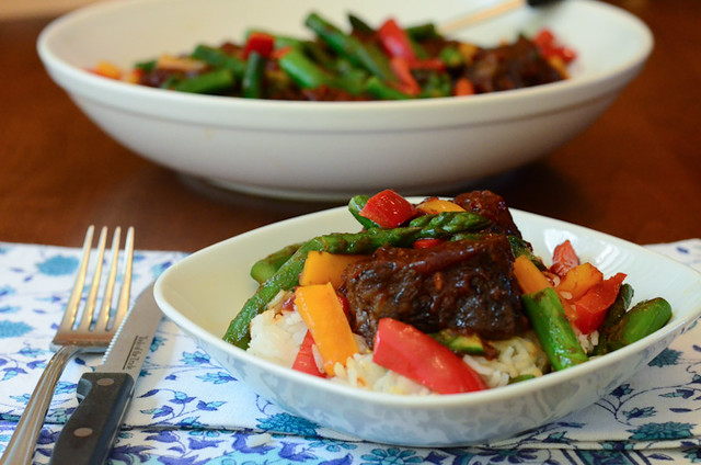 A serving of Asian BBQ Ribs with Rice and Stir Fried Vegetables in a white serving bowl.