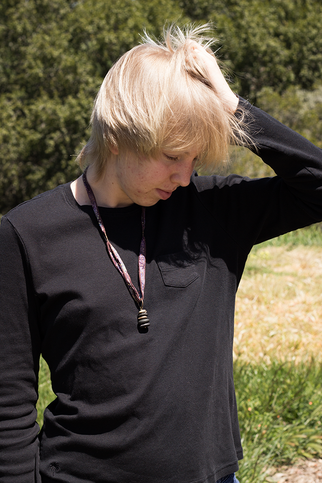 stone pendant necklace, black long-sleeve shirt, warm sunshine