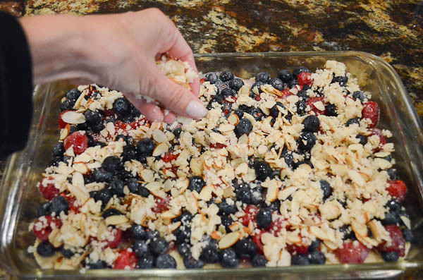 The crumb mixture being sprinkled on top of the Red White and Blue bars.