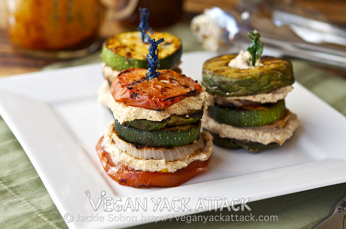 Stacked grilled veggies with layers of smoky almond cream on a white plate