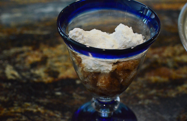 A cup with some coffee granita with whipped cream layered on top.