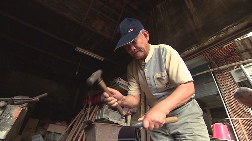 百年打鐵店的老工匠細心修復鐮刀