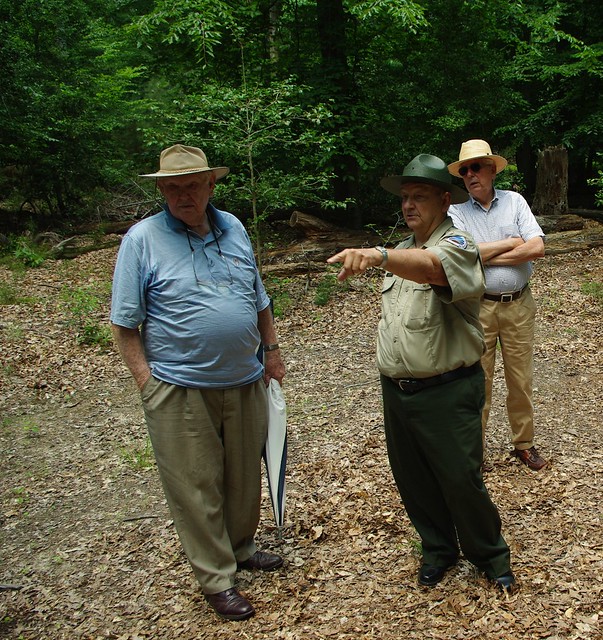 Jerry Travers points out parts the location of wheelwright house to visitors on an archaeological tour.