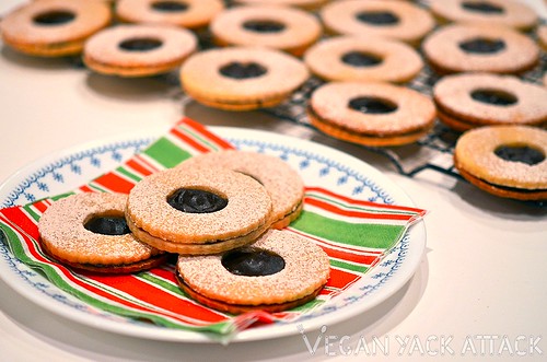 Chocolate linzer cookies stacked together on a holiday napkin