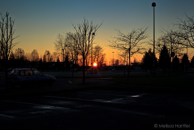Sun setting over a parking lot