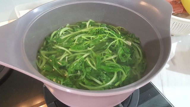 The making of mee hoon kueh - adding water to spinach