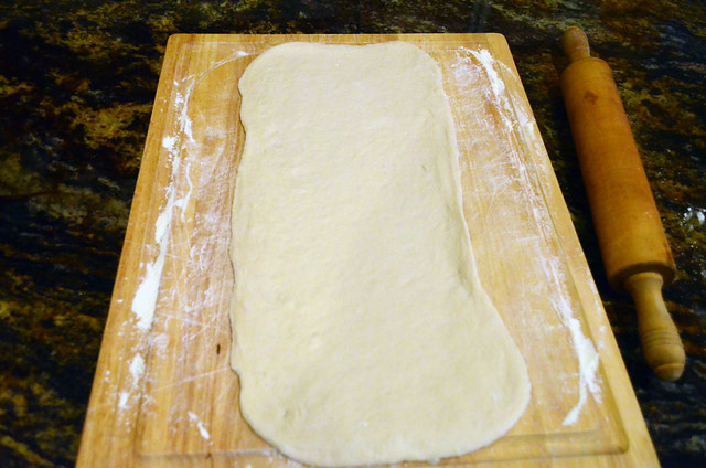 Dough rolled out on the cutting board into a rectangle.