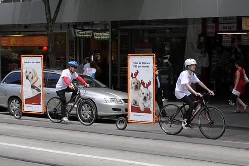 Cyclists towing advertisements behind their bikes