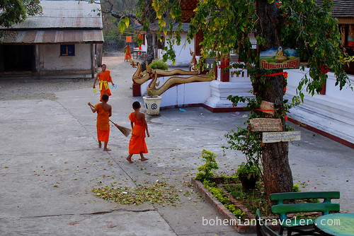 novice monks sweeping at Vat Manorom in Luang Prabang Laos