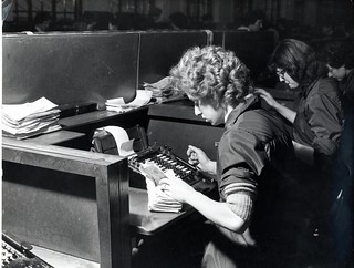 Clearing Department, woman sorting cheques and using adding machine - 1960s