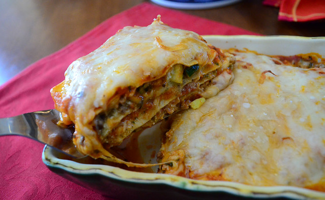 A slice of lasagna on a spatula being taken from the pan.