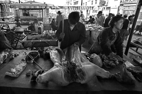 cina market pig vendor blackwhite black white bianco e nero marellaluca marella luca travel analogic film street people golmud bw bn pb butcher animal food pork slaughtered