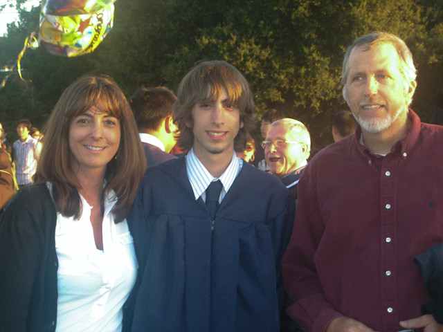 Valeries standing with Boy#2 and her husband at a graduation. 