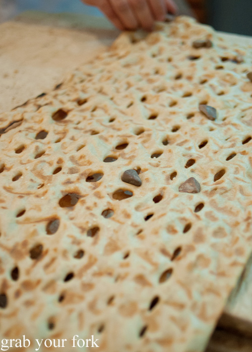 Freshly baked sangak Persian bread with pebbles during a Frying Pan Adventures food tour in Dubai