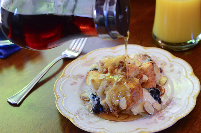 Maple syrup is poured on to a serving of Blueberry Almond French Toast Bake.