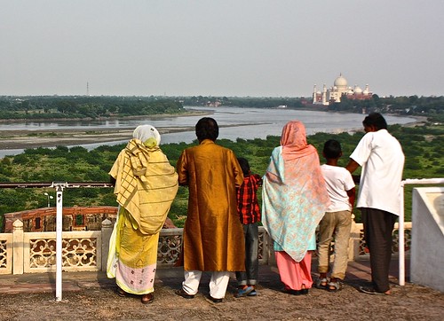 A family looks out at the Taj Mahal from Agra Fort