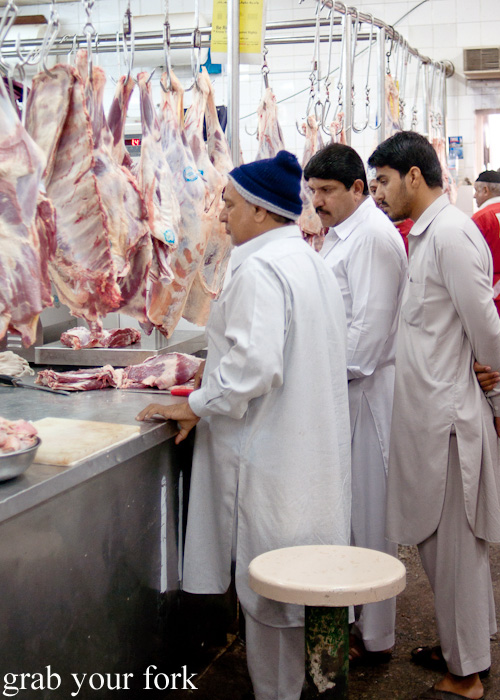 Butcher and shoppers next to Dubai Fish Market in Deira