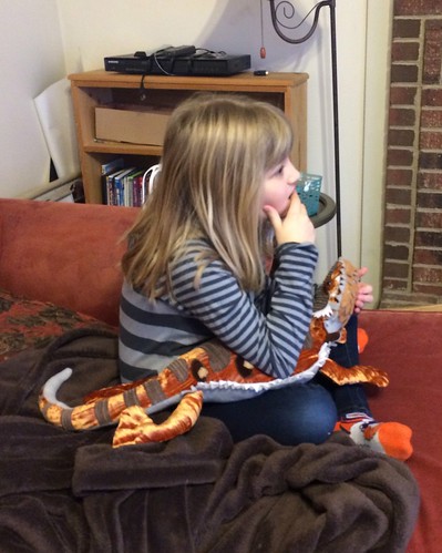 Watching Scooby Doo before school with her new toy bearded dragon.