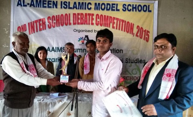 Habib Ahmed of Al-Ameen Islamic Model School is seen receiving the Best Debater’s trophy from the hands of Bilayat Hussain in the 2nd Inter School Debate Competition 2015 held on Saturday at Goroimari, Kamrup District.