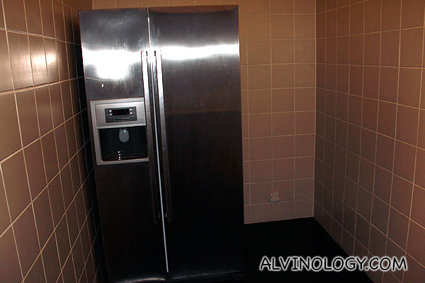 Giant fridge tucked in a corner as it's modern appearance do not gel so well with the overall interior design 