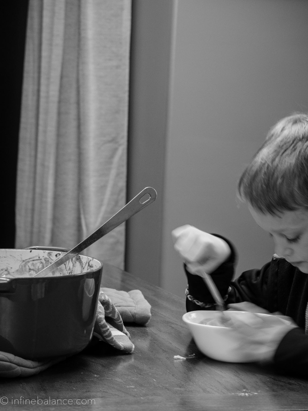 black & white photo, boy eating cauliflower mac and cheese