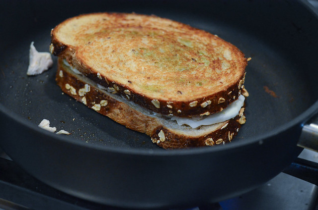 The sandwich is flipped to the other side and cooked in the skillet.