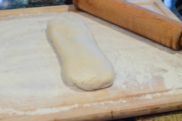 Bread dough on a floured wood board.