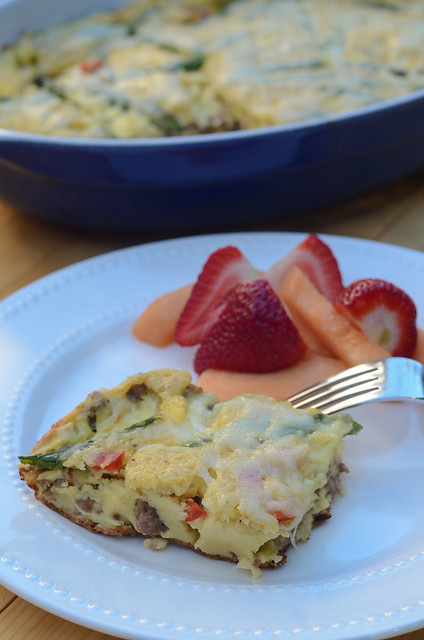 A slice of Turkey Asparagus Breakfast Bake on a white plate with fruit.
