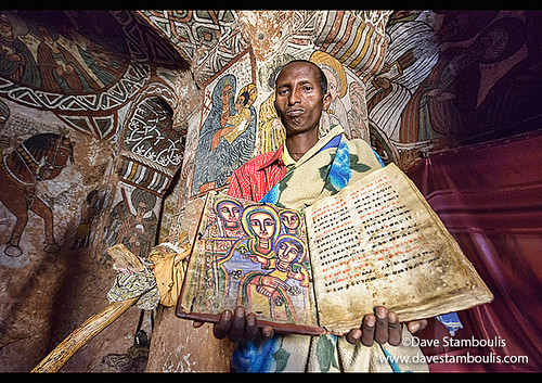 priest reading hundred years old Bible in the Abuna Yemata Guh rock church in Tigray, Ethiopia