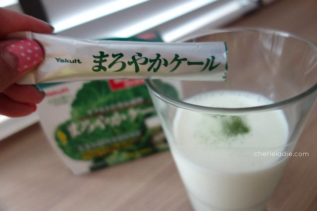 Pouring the maroyaka kale sachet into in a glass of milk. 
